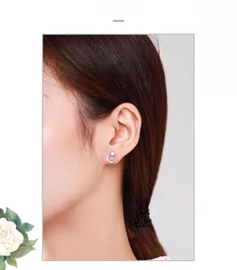 Close-up of S925 sterling silver crescent moon earrings with pave zircons on ear