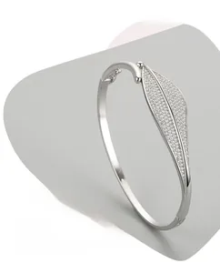 Macro detail of leaf-shaped open silver bracelet showing S925 hallmark and micro-pave zircons