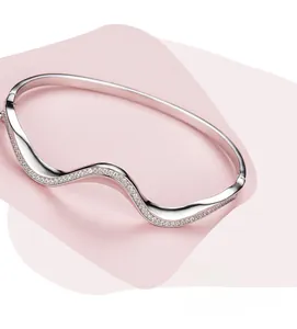 Macro shot of micro-pave white zircon inlay on s925 silver wavy bangle bracelet