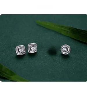 Detail of round and square halo stud earrings with micro-paved crystals on green background
