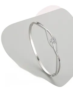 Detail of s925 silver wave bangle featuring a sparkling zircon flower and polished finish