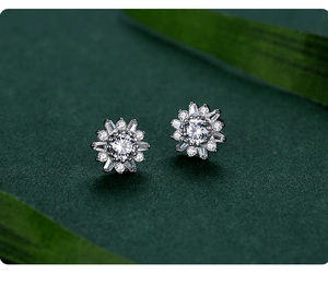Vue macro de boucles d'oreilles tournesol en argent S925 avec sertissage de diamants