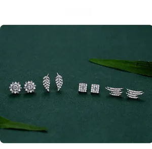 Detail of four S925 silver stud earrings including floral and leaf shapes with cubic zirconia