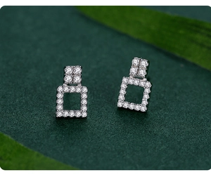 Macro shot of silver square hollow earrings with sparkling pavé cubic zirconia setting