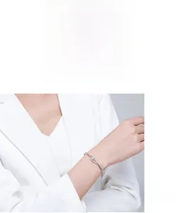Detail of s925 silver interlocking infinity bracelet with zircons on model's wrist