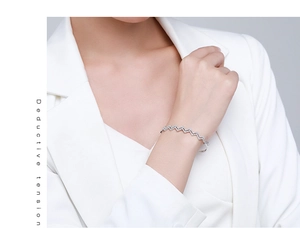 Detail of s925 silver wave bangle featuring micro-paved white zircon stones on wrist