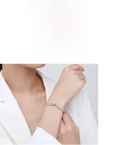 Simple V-shape silver bangle with sparkling zircons shown on a model's wrist