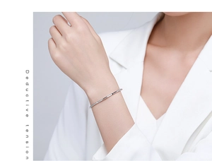 Detail of s925 silver minimalist open bangle with micro-pave zircons on a model wrist