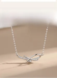 Macro detail of silver bow pendant with pavé crystals and single round cubic zirconia