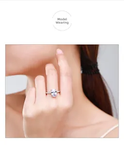 Gros plan d'une bague avec diamant ovale de 3 carats sur la main et serti pavé