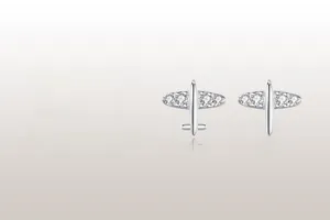 Detail of silver airplane earrings featuring sparkling pavé crystals and mirror reflections