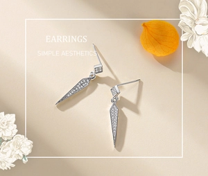 Macro detail of S925 silver geometric drop earrings with sparkling pavé cubic zirconia