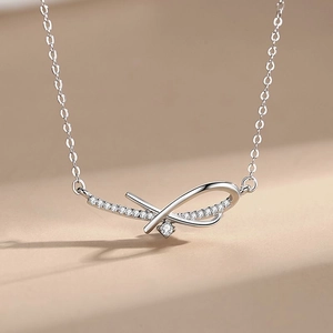 925 Sterling Silver Bow Necklace with shimmering cubic zirconia on light camel background
