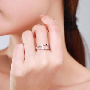 Elegant s925 silver crossover ring with pavé zircons worn on model's hand