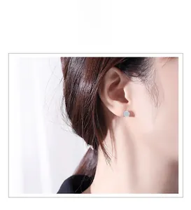 Detail of s925 silver round stud earrings with micro-pave crystals on model
