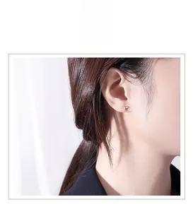 Close-up of minimalist S925 silver airplane stud earring with pavé zircon wings on model