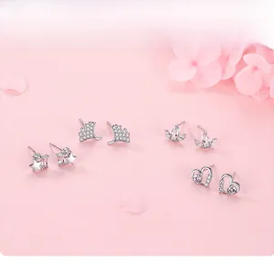 Detail shot of four sterling silver stud earrings with stars and hearts on pink petals
