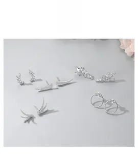 Detailed view of silver hoop earrings and studs with intricate zircon inlay designs