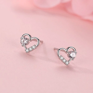 S925 sterling silver heart stud earrings with cubic zirconia on pink background