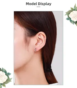 Detailed view of a silver snake stud earring with sparkling stones on model ear