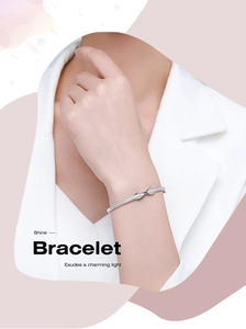 Macro shot of s925 silver knot bracelet with crystals on model wrist in suit