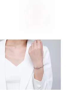 Detail showing elegant minimalist double-layered silver bangle worn on model's wrist