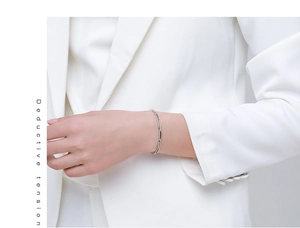 Detail of silver bamboo-style minimalist bracelet with micro-zirconia inlay on female wrist