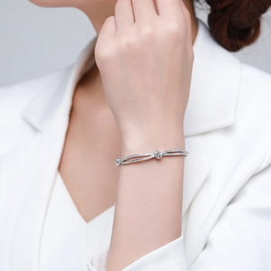 Bracelet jonc noeud en argent S925 avec diamants pavés sur un mannequin en costume blanc