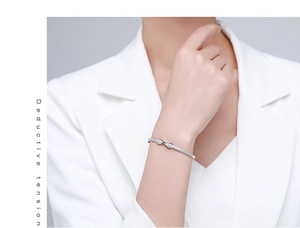 Macro detail of silver twisted infinity bracelet with sparkling zircon micro-paving stones