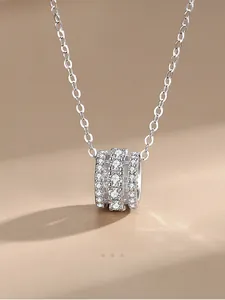 Vue macro du pendentif cylindre en argent S925 avec trois rangées de zircons micro-pavés