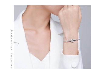 Close-up of s925 silver open bangle with pavé zircons on model in white suit