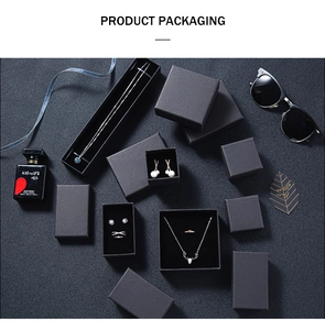 Macro view of minimalist black jewelry packaging sets with soft matte texture and velvet lining
