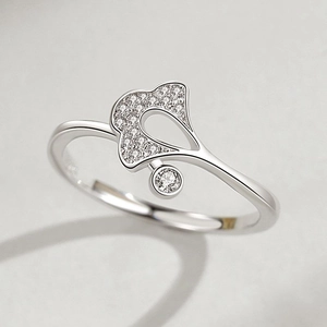 Bague feuille de ginkgo en argent S925 sertie de zircons sur fond gris texturé