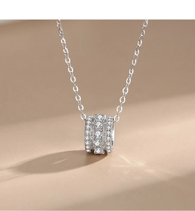 Vue macro du pendentif cylindre en argent avec trois rangées de zircons cubiques pavés
