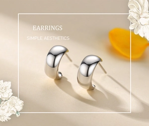 Close-up of minimalist S925 sterling silver C-shaped stud earrings with a polished finish