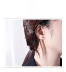 Close-up of s925 silver crown stud earrings with sparkling diamonds on a female ear