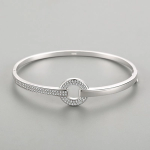 Polished S925 sterling silver bangle featuring a circular centerpiece paved with zircons