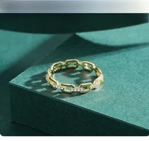 Detailed close-up of a gold chain ring featuring intricate pave-set sparkling crystals