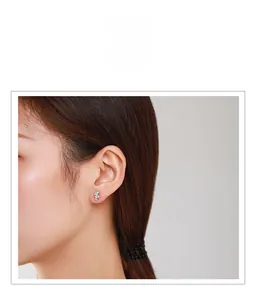Gros plan d'une boucle d'oreille goutte en argent avec zircons portée par un mannequin