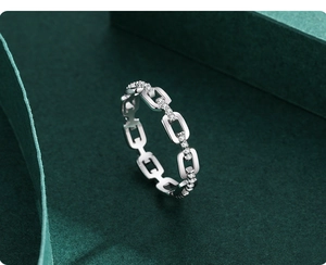 Detailed view of S925 silver chain ring with pavé diamonds on textured dark pedestal