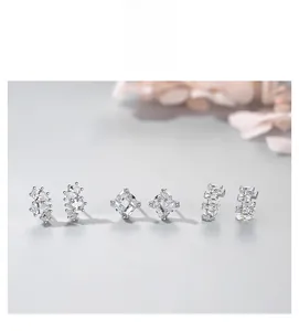 Détail de trois boucles d'oreilles en argent avec zircons en forme de poire et de rectangle