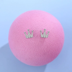 Sparkling S925 sterling silver crown stud earrings with white zircon on pink display