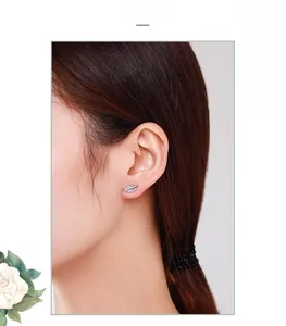 Close-up of s925 silver feather stud earrings with sparkling crystals on model ear