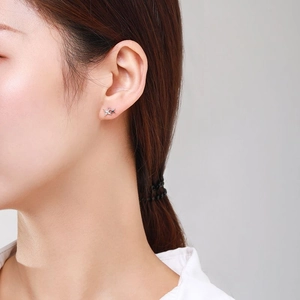 S925 sterling silver star stud earrings with zirconia stones worn on a female model