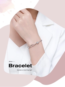 Dettaglio del bracciale cuore incrociato in argento S925 con diamanti sul polso donna