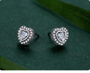 Macro shot of S925 sterling silver heart stud earrings with halo cubic zirconia setting