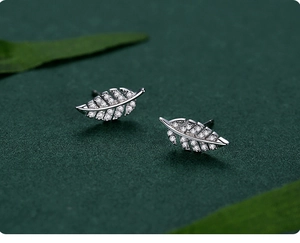 Macro view of leaf-shaped silver stud earrings with pavé set white cubic zirconia
