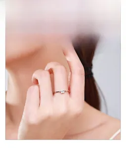 Gros plan d'une bague en argent 925 minimaliste avec zircon carré étincelant sur un doigt