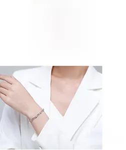 Close-up of minimalist S925 silver layered bracelet with cubic zirconia on female model