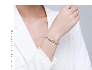 Macro detail of silver geometric bracelet encrusted with fine zircon stones on model